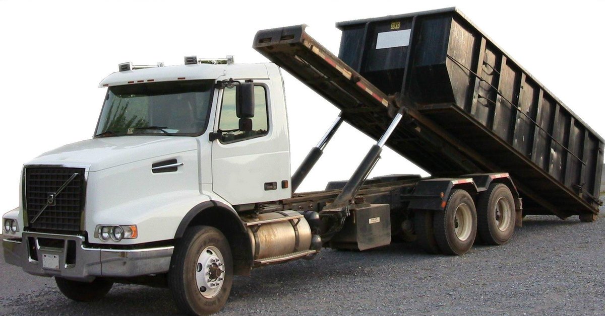Roll-off truck carrying an empty disposal bin